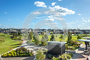 View over a public park with many residential houses in the distance.