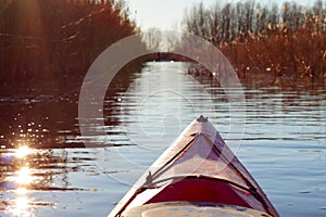 View over river at calm winter day. Bow of red kayak in the Danube river