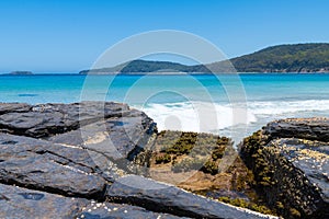 View over rocks at Pebbly Beach, a popular camping area with great surfing beach and bush walks within Murramarang National Park,