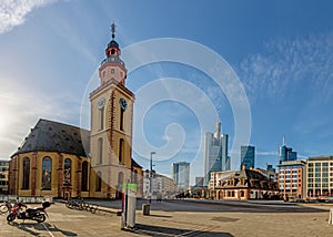 View over the square at the Hauptwache in Frankfurt with St. Catherine`s Church and skyscrapers of the skyline in morning light
