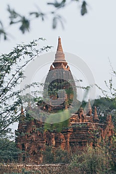 View over stupas and pagodas of ancient Bagan temple complex during sunrise golden hour in Myanmar