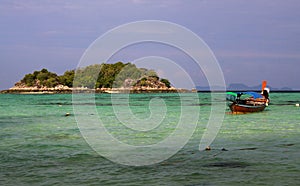 View over turquoise bay contrasting with blue sky on tiny  island with long tail boats on Ko Lipe, Thailand