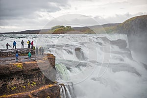 View over waterfall wonder Gullfoss in South Iceland, Golden Circle, at summer with dramatic sky and tourists at the observation