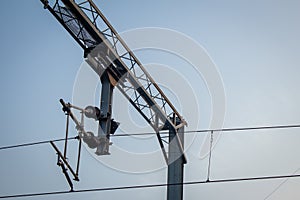 View of overhead electric lines used by train locomotives. Pole supporting the power lines used by electric train engines