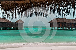 View of overwater bungalow beach villas in the Maldives on a rainy overcast day