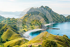 View of Padar Island in a cloudy evening with blue water surface and tourist boats