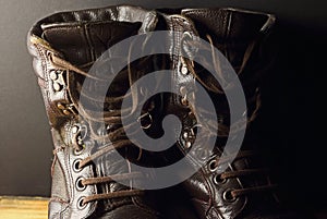 CLOSE VIEW OF A PAIR OF COMBAT BOOTS WITH LOOSE LACES