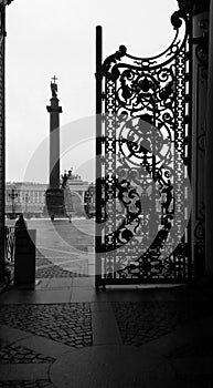 View of the Palace Square and the Alexandrian Column with an Angel through an open cast-iron gate, St. Petersburg, Russia. Black a