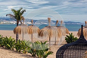 View of palapas on the beach in Marbella, Spain.