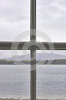 The view from a 4 paned window in a house at Appin, looking over the Sea loch and the Mountains beyond on a wet day in April.