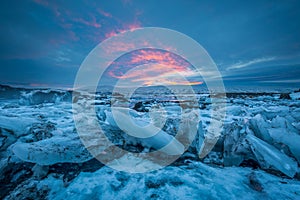 A view on panning floes, under a colored sunset sky near waterfalls.