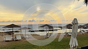 View on the parasols with deck chairs on beach near the sea