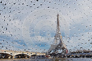 View on Paris city through water drops on glass after rain. Weather and forecast concept