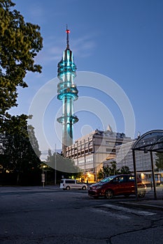 A view from a parking lot with an illuminated TV broadcasting tower