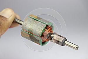 View of part from disassembled electric motor. DC motor Rotor held in the hand