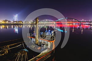 View at the part of an old ship, old railway bridge and distant city lights at night, Belgrade, Serb
