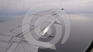 View from the Passenger Airplane Window on the Wing Flying above the Clouds