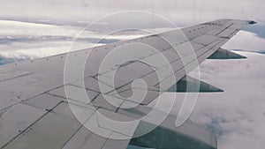 View from the Passenger Airplane Window on the Wing Flying above the Clouds