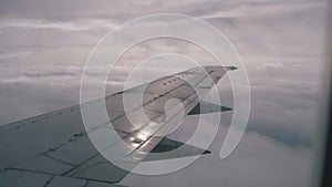 View from the Passenger Airplane Window on the Wing Flying above the Clouds