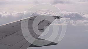 View from the Passenger Airplane Window on the Wing Flying above the Clouds