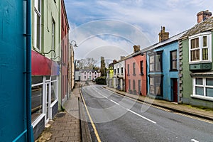 A view past colourful houses towards the castle ruins on the main road into Narberth, Pemborkeshire, Wales