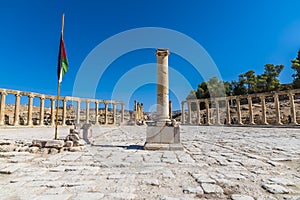 A view past a column across the Oval Plasa in the ancient Roman settlement of Gerasa in Jerash, Jordan