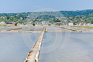 A view past crystallisation pools towards the town at the salt pans at Secovlje, near to Piran, Slovenia