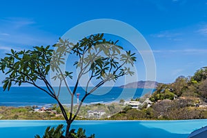 A view past a pool over the resort of Tamarindo towards the bay in Costa Rica