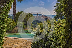 A view past a pool towards the Umbrian village of Collazzone near Todi, Italy