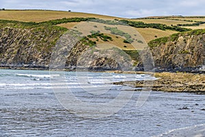 A view past  rock pools on the beach at low tide at Newport, Pembrokeshire, Wales