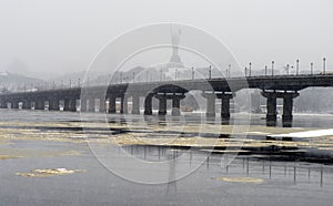 View of the Paton Bridge in winter. Snowfall in Kiev near the Dnieper River. Timelapse