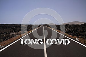 View on paved empty road through dry stony desert with text: long covid