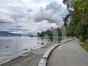 View of Paved Trail in Stanley Park, Vancouver, with Clouds and Water