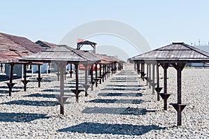 View of the pebble beach. a well-equipped beach with fungi giving shade. devices on the beach for shade