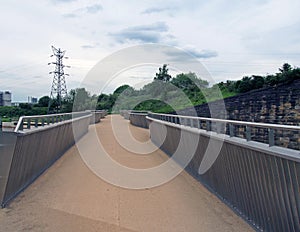 View of the pedestrian footbridge crossing the weir on the river aire at knostrop leeds with electricity pylons in a