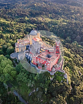 View of Pena Palace, a colorful Romanticist castle building on hilltop during a beautiful sunset, Sintra, Lisbon, Portugal. photo