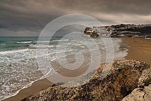 view of Peschici Bay and clifftop town under a rainy and overcast sky