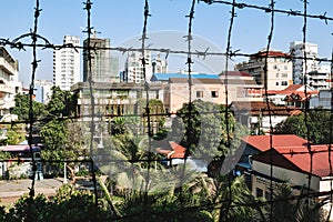 View on Phnom Penh through barbed wire fence from S21 Tuol Sleng Genocide Museum Phnom Penh Cambodia