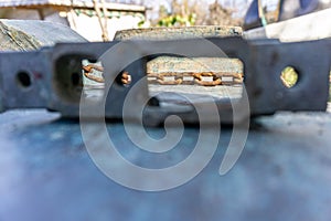 View through the piece of metal onto rusted chain