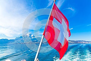 View of Pilatus Mountain and swiss flag from Lake Lucerne, Switzerland