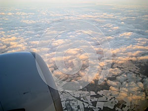 View from the plane with the engine, clouds and snowy lands
