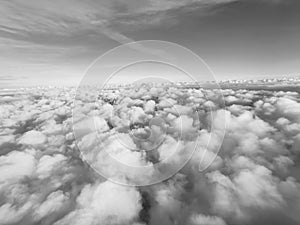 View from the plane to white volumetric thunderclouds and the space of the stratosphere, black and white, top view