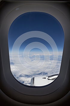 View from plane window with light clouds and blue sky