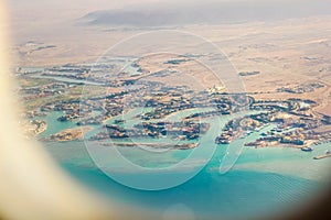View from a plane window on the resort beach area of the Red Sea. It is visible a part of the desert, lodges of hotels,
