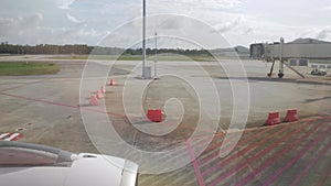 view through plane window to outside with view of plane engine while aircraft parking at airside area in the airport ready to