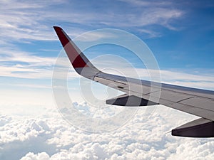 View of plane wing flight flying in sky among white cloud, tourism operators and travel concept