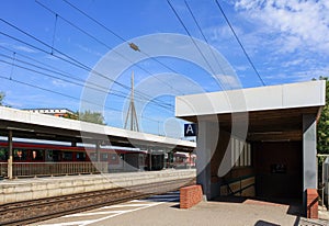 View of platform and train track at Elmshorn train station in summer with clouds in blue sky background. No people.