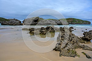 View on Playa de Borizo in Celorio, Green coast of Asturias, North Spain with sandy beaches, cliffs, hidden caves, green fields photo