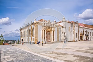 View of plaza of University of Coimbra, with tourists and building of the Joanina Library, in Coimbra, Portugal