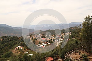 View from a view point mirador onto San Jose del Pacifico, a small village in Oaxaca, surrounded by a dense forest and hills, photo